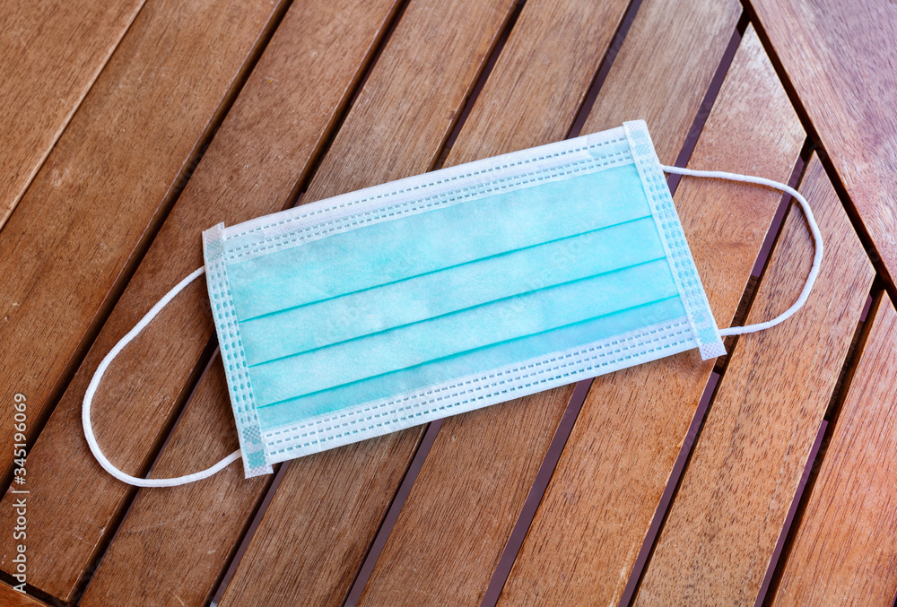 Face mask or surgical mask lays on wooden table Face mask or surgical mask lays on wooden table