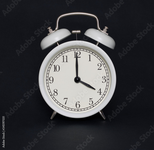 Old-style alarm clock, black and white, it's four o'clock.
