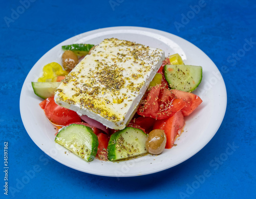 Greek salad plate with original feta cheese, olives, green pepper slices, tomatoes, onions and cucumber slices