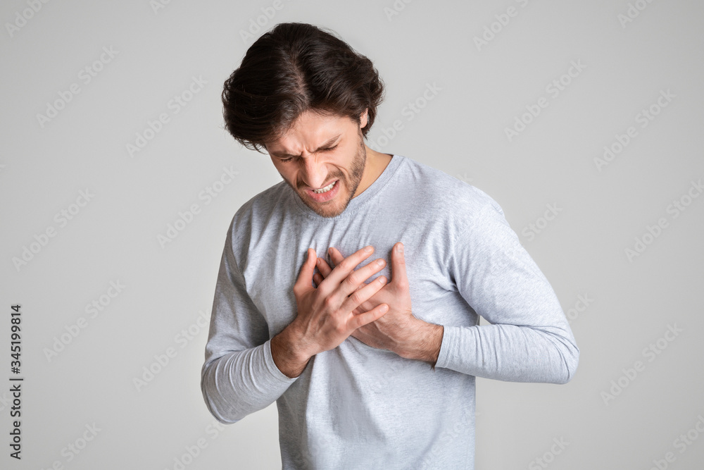 Man suffering from chest pain with painful expression Man suffering from chest pain with painful expression