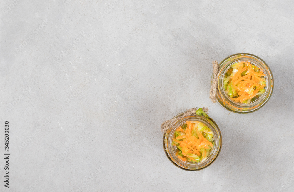 Cabbage salad with carrots in a jar on a light background top view Cabbage salad with carrots in a jar on a light background top view