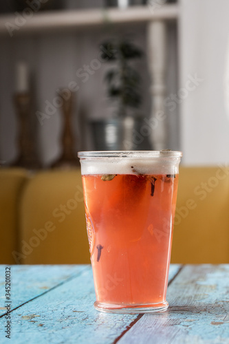 Glass with strawberry mojito cocktail with lemon and mint, cold refreshing drink or beverage with ice on gray background. Overhead view, copy space. Advertising for cafe menu.