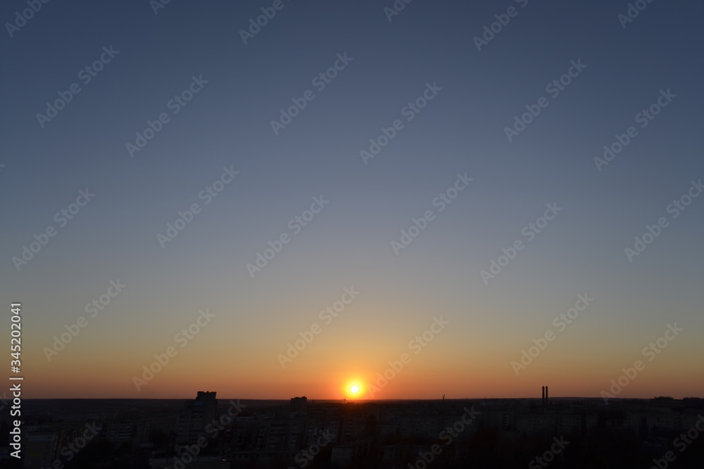Sunset on clear blue sky over the buildings in the city Sunset on clear blue sky over the buildings in the city
