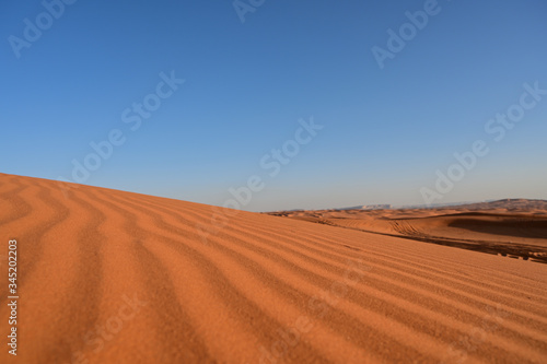 Red sand in the Arabian desert and mountain top at the background (Tuwaiq). In Saudi Arabia near Riyadh (Mozahmeia area)