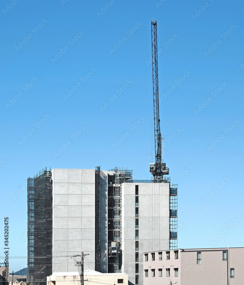 Building series. Vertically extended industrial crane on the new Multistory Unit building under construction at 277 Mann St. Gosford. March 18, 2020.