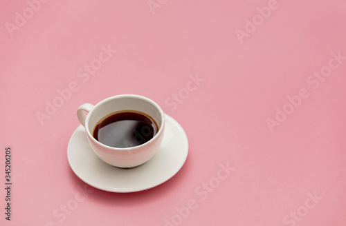 White cup of coffee on pink background