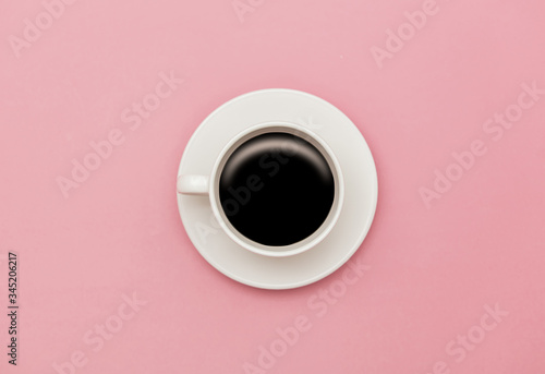 White cup of coffee on pink background