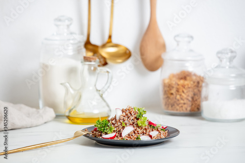 boiled buckwheat with radish and fork on a plate  vegetarian dish