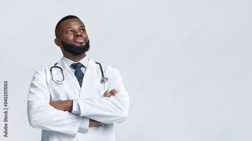 Happy medical doctor in white robe looking at copy space Happy medical doctor in white robe looking at copy space