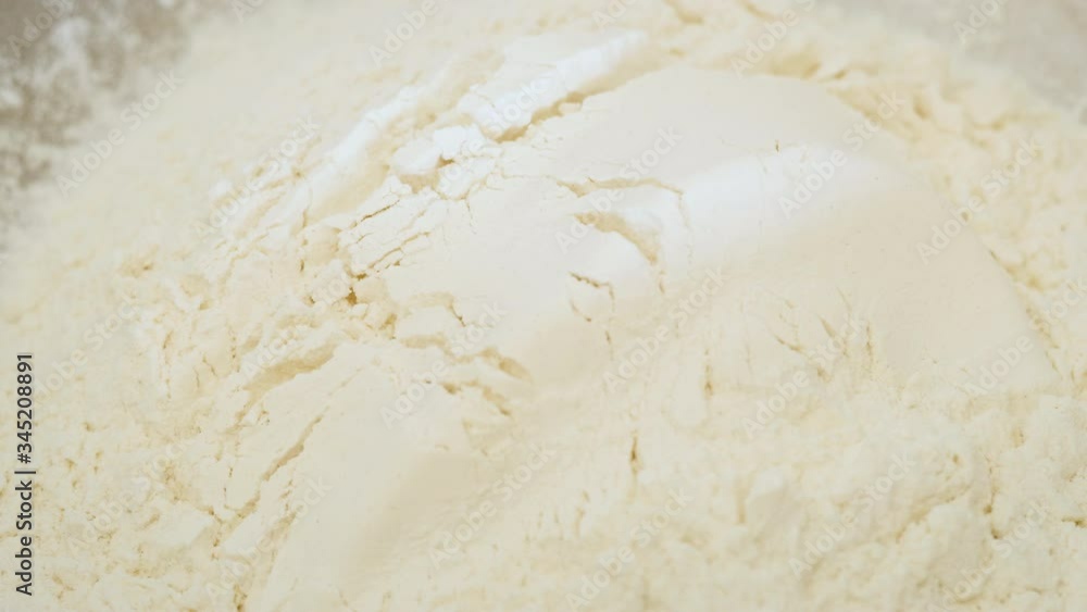 Dumping bread flour into a bowl. Adding white all-purpose flour to be mixed into bread dough. Home bakers are experiencing flour shortages due to panic buying and rationing due to the covid19 lockdown Dumping bread flour into a bowl. Adding white all-purpose flour to be mixed into bread dough. Home bakers are experiencing flour shortages due to panic buying and rationing due to the covid19 lockdown