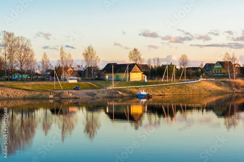 urban village or village with wooden houses located on the blue river bank, early spring evening at sunset
