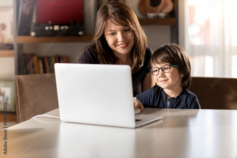 Mother and boy studying with laptop in home. Mother and boy studying with laptop in home.