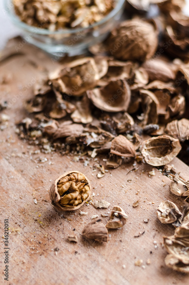 Half of walnut on the wooden board in the kitchen during autumn season. Foraging and cleaning nuts at home. Half of walnut on the wooden board in the kitchen during autumn season. Foraging and cleaning nuts at home.