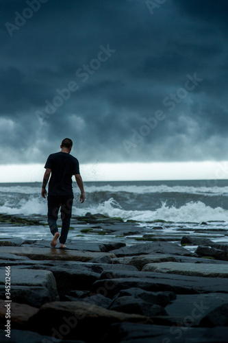 man walking on stormy coast