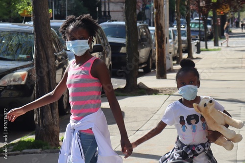 Принти на полотні Black girls wearing face maskes outdoors on city sidewalk
