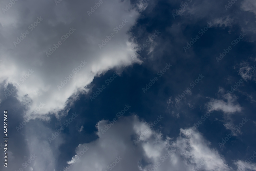 Background with dark blue sky and white clouds and sunlight