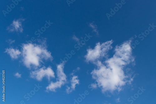 Dark blue sky with small fluffy clouds  horizontal photo