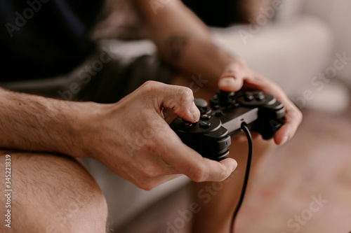 Fotografie Hipster man plays video games on a couch