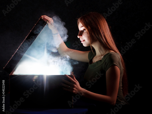 Fotografia Cute girl found a treasure open mystrey box with smoke and light inside