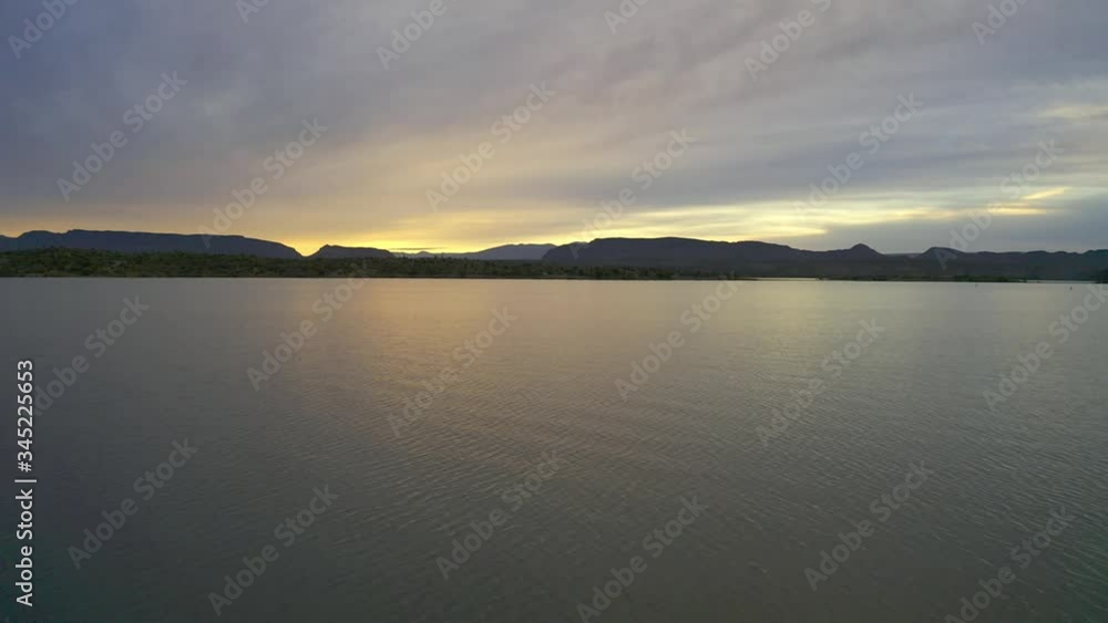 Flying low over a lake during sunrise with mountains in the distance. Lake Pleasant, Arizona. Flying low over a lake during sunrise with mountains in the distance. Lake Pleasant, Arizona.