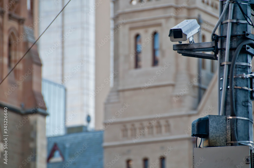 Surveillance CCTV street outdoor camera watching pedestrian near