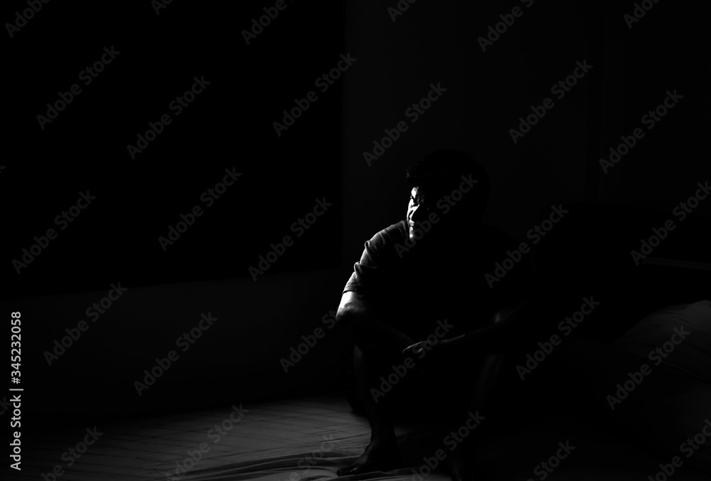 Dark male in hopeless emotional, black and white serious look. Real people in sadness feel and lonely in room.