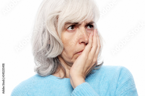 Elderly woman suffering from toothache on white background