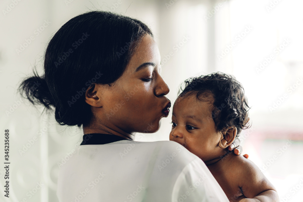 Portrait of enjoy happy love family african american mother playing with adorable little african american baby.Mom touching with cute son moments good time in a white bedroom.Love of black family Portrait of enjoy happy love family african american mother playing with adorable little african american baby.Mom touching with cute son moments good time in a white bedroom.Love of black family