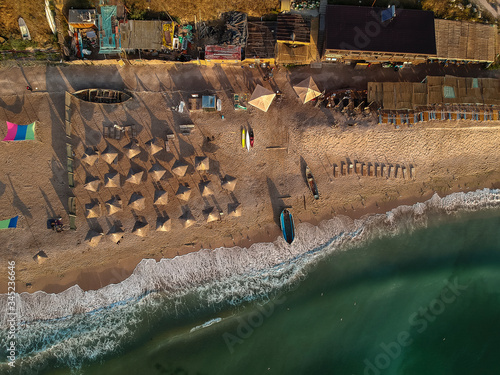 Aerial view of amazing beach with umbrellas and turquoise sea at sunrise. Black Sea at Vama Veche, Romania photo