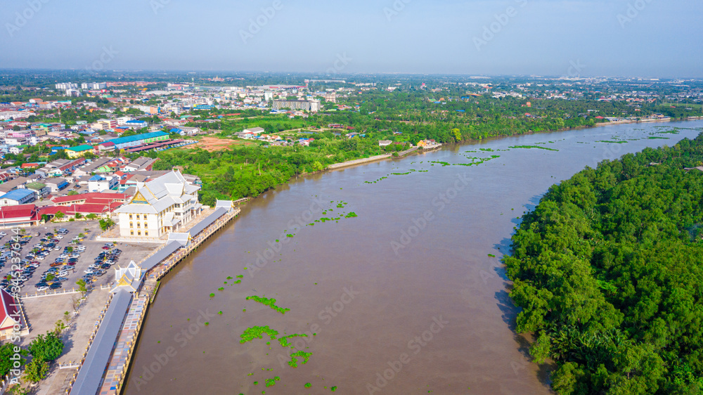 Aerial view of community, temple and building along the Bang Pakong river in Chachoengsao province, Thailand.
