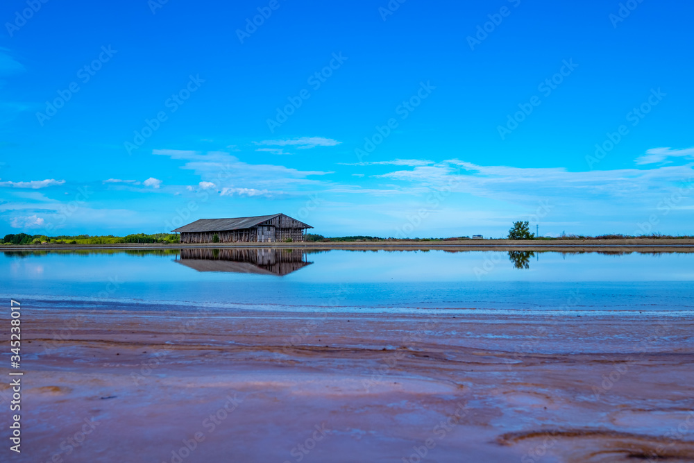 Salt barn with blue sky background in salt fields at Bang Tabun city of Petchaburi province, Thailand