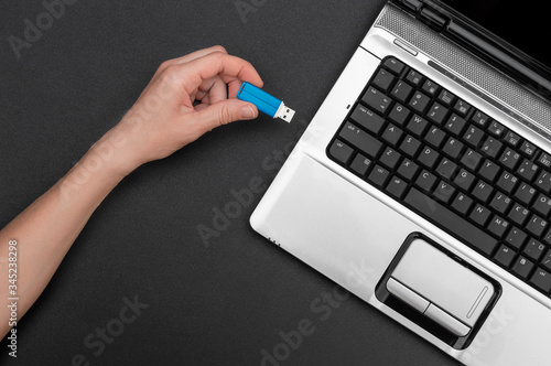 Vászonkép Hand connecting usb flash drive to notebook.