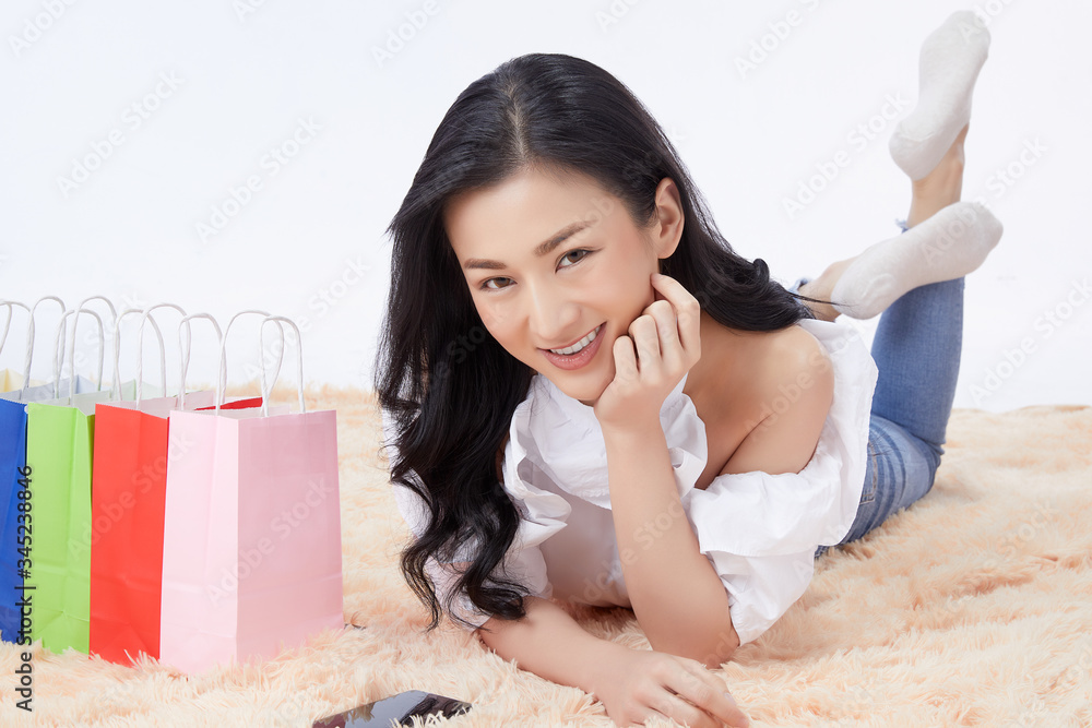 asian woman with shopping bag and credit card with mobile phone for online shopping at home. Concept shopping online. asian woman with shopping bag and credit card with mobile phone for online shopping at home. Concept shopping online.