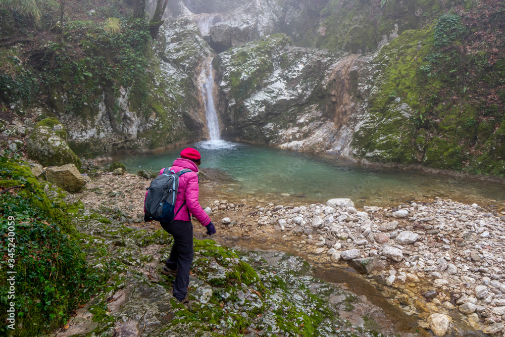 woman hiker photographing waterfall in sassinoro and fog woman hiker photographing waterfall in sassinoro and fog