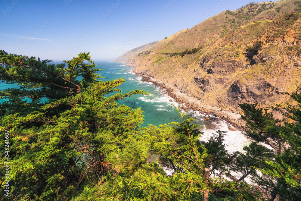 Big Sur at Ragged Point, California Coastline. Scenic view of cliffs and Pacific ocean, framed by Cypress trees Big Sur at Ragged Point, California Coastline. Scenic view of cliffs and Pacific ocean, framed by Cypress trees