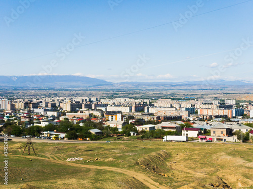 Panoaramic view to Rustavi city buildings, mountains in the background;  E60 highway with lorry and cars driving. Concept of trasnportation and travel in big cities. Georgia.2020 photo