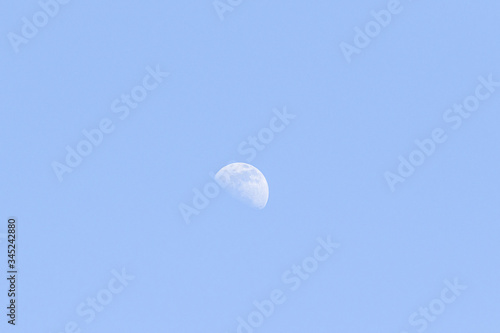 The moon against the blue sky day.