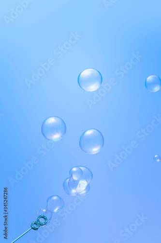 Blowing soap bubbles on blue background