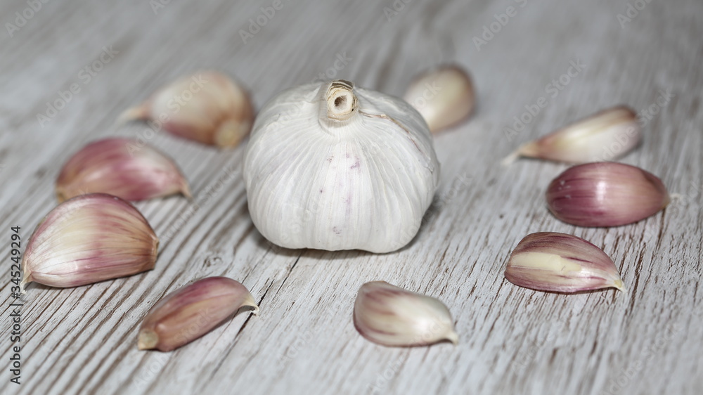 Garlic surrounded by cloves in circle on wooden table close up