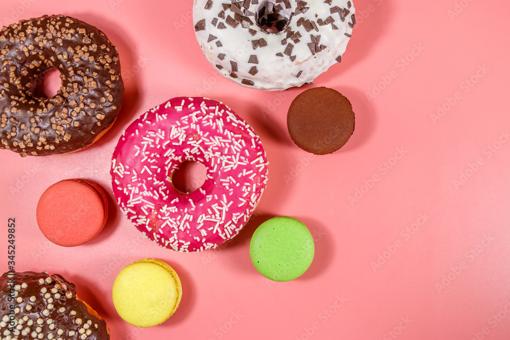 Tasty donuts and macaroons on pink background. Top view Tasty donuts and macaroons on pink background. Top view