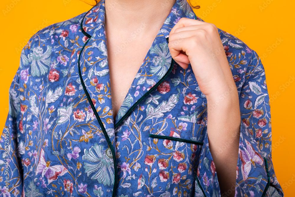 Close up of girl in home wear pajama over colorful yellow background.