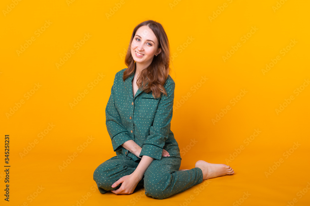 Young girl posing in pajamas on yellow background. Relax good mood, lifestyle and sleepwear concept. Young girl posing in pajamas on yellow background. Relax good mood, lifestyle and sleepwear concept.