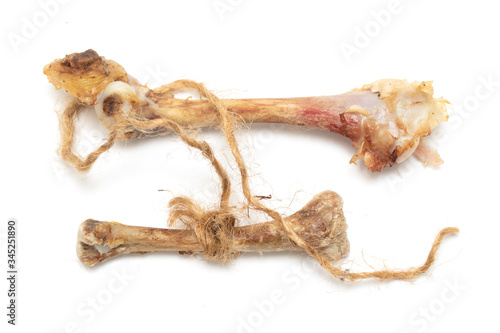 A chicken bone weighs on a rope on a white background.