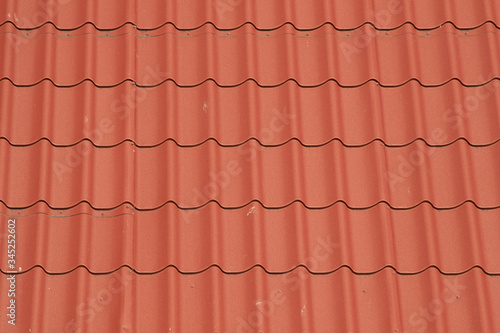 The texture of metal tiles on the roof of the house.