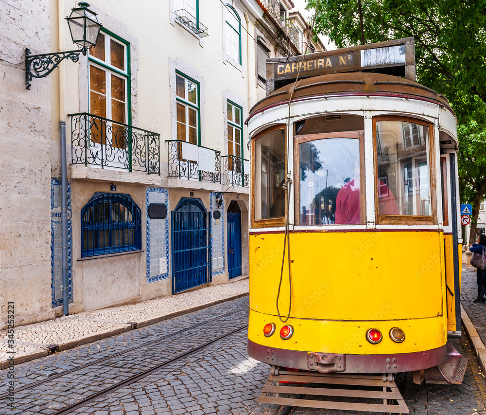 Typical old tram crowded with tourists crisscrossing Lisbon in Portugal