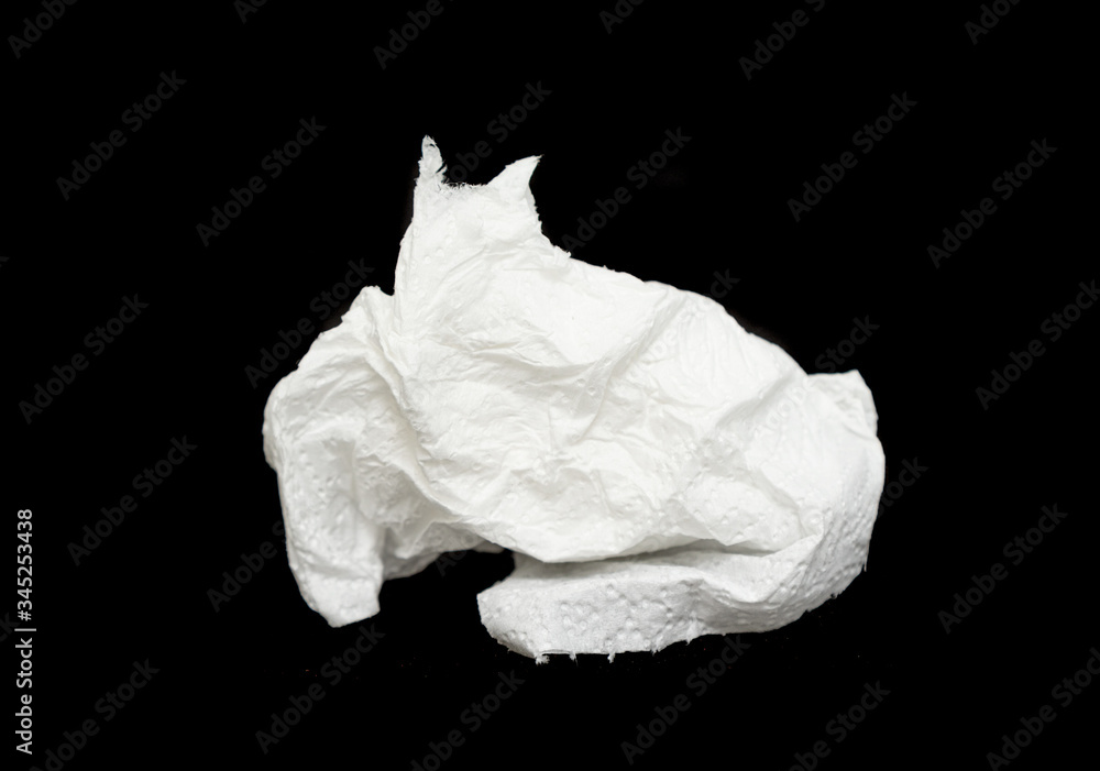 White crumpled napkin, toilet paper on a black background.