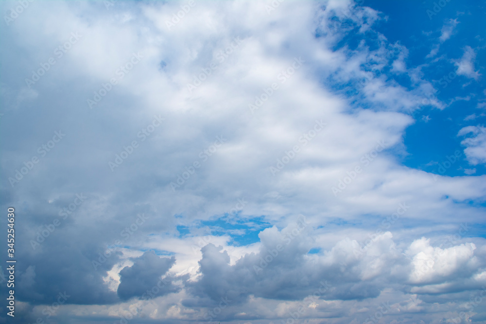 Fototapeta premium Horizontal view of a light, blue sky with white clouds. Airy, vibrant atmosphere