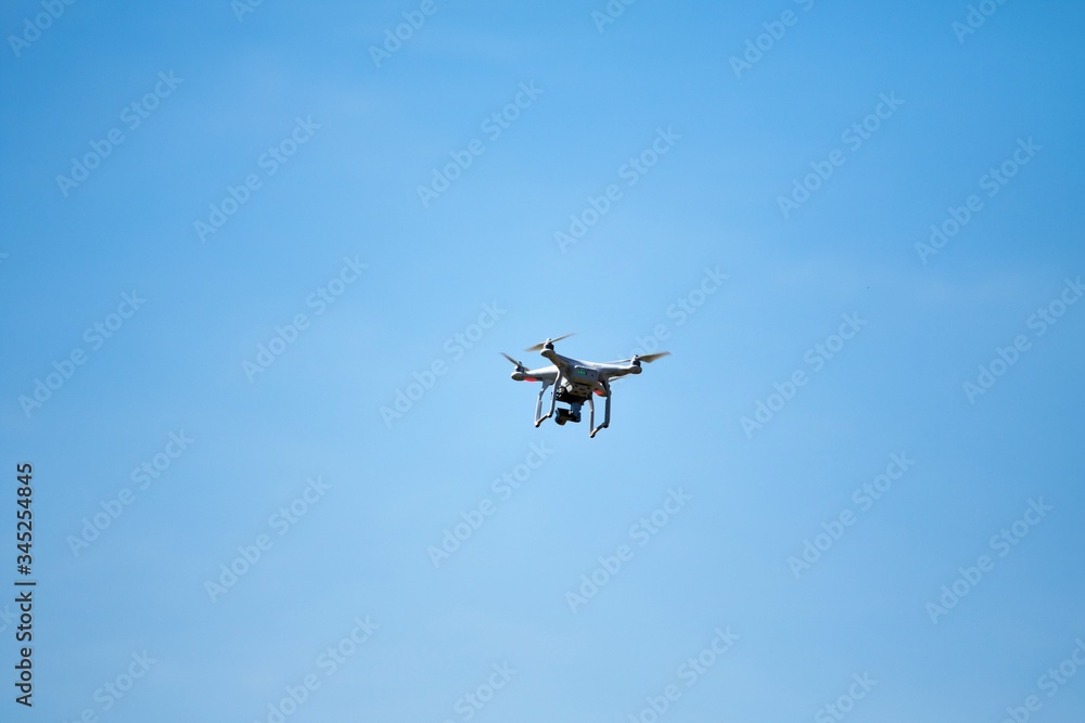 White flying drone on a blurry background of nature. White flying drone on a blurry background of nature.