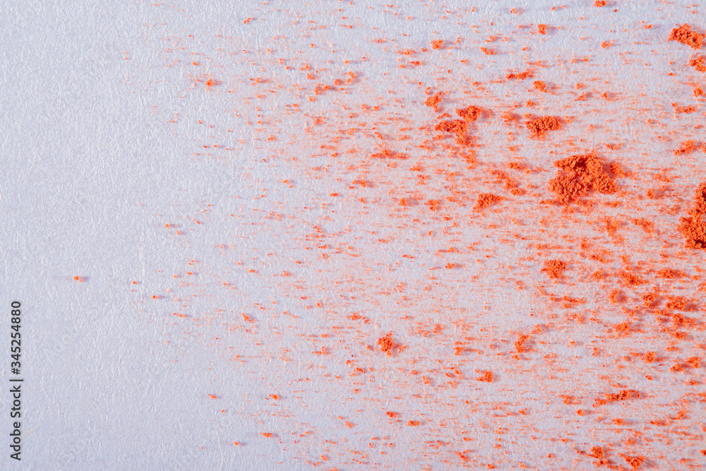 Fototapeta premium Background with sprinkled paprika at high magnification and an empty white background with a place for inscriptions