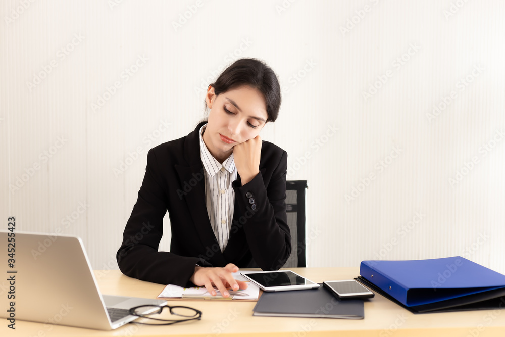 Business woman get bored of job. Attractive beautiful young employee female do not want to work anymore in this company. She look down and unhappy. laptop computer, paperwork, tablet, phone on desk Business woman get bored of job. Attractive beautiful young employee female do not want to work anymore in this company. She look down and unhappy. laptop computer, paperwork, tablet, phone on desk